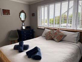 A bedroom with a bed and dresser at Stonecroft in Praa Sands