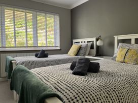 A bedroom with two beds and a window at Stonecroft in Praa Sands