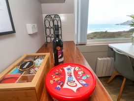 A kitchen with a bottle of wine and a box of sweets at Stonecroft in Praa Sands