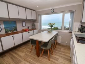 A kitchen with cabinets and a dining table at Stonecroft in Praa Sands