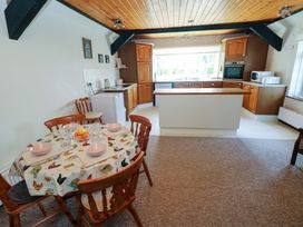 A kitchen with a dining table and chairs at The Stables in St Athan