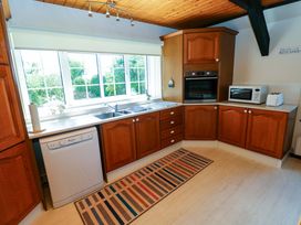 A kitchen with cabinets, sink, and appliances at The Stables in St Athan
