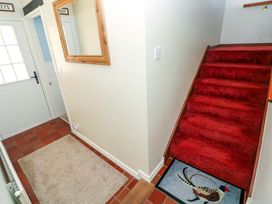 A hallway with a staircase and a mirror at The Stables in St Athan