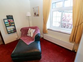 A snug area with a chaise lounge and a shelf at The Stables in St Athan
