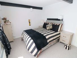 A bedroom with a bed and nightstands at The Stables in St Athan
