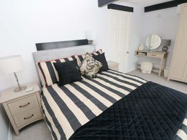 A bedroom with a bed and bedside table at The Stables in St Athan