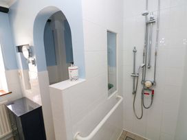 A bathroom with a shower and mirror at The Stables in St Athan