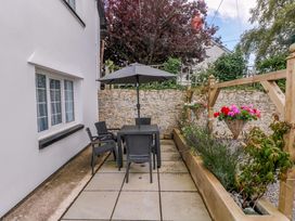 A garden with a table and chairs under an umbrella at The Stables St Athan
