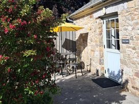 An outdoor seating area with a table and chairs at Carreg Cennen Cottage in Llandeilo