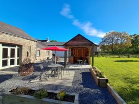 An outdoor patio area with table and chairs at Carreg Cennen Cottage in Llandeilo