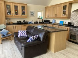A kitchen with a sofa and appliances at Awel Deg, Newport, Pembrokeshire