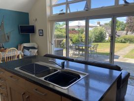A kitchen with a sink and chairs at Awel Deg, Newport