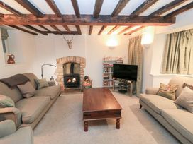 A living room with a fireplace and television at Butlers Cottage in Burford