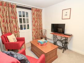 A living room with a coffee table and a television at Butlers Cottage in Burford
