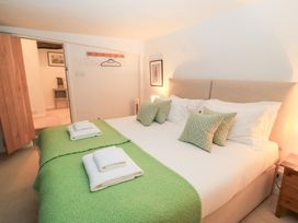 A bedroom with a bed and bedside table at Butlers Cottage Burford