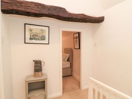 A hallway with a beam and a table at Butlers Cottage in Burford