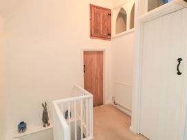 A hallway with a staircase and a rabbit statue at Butlers Cottage Burford