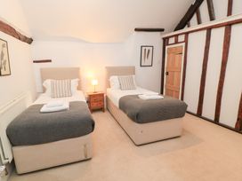 A bedroom with two single beds and a nightstand at Butlers Cottage in Burford
