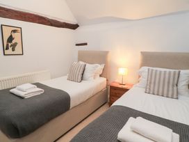 A bedroom with two beds and a lamp at Butlers Cottage in Burford