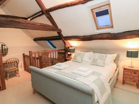A bedroom with a bed and a desk at Butlers Cottage in Burford