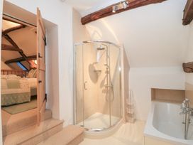 A bathroom with a shower and bathtub at Butlers Cottage in Burford