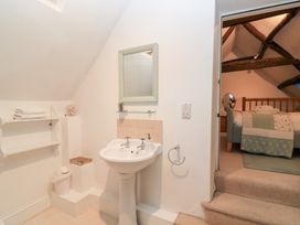 A bathroom with a sink and mirror at Butlers Cottage in Burford