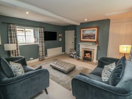 A living room with sofas and a fireplace at Black Horse Cottage in Swainby