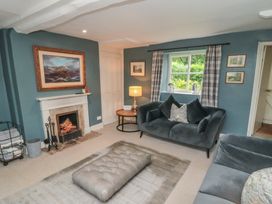 A living room with a fireplace and seating area at Black Horse Cottage in Swainby