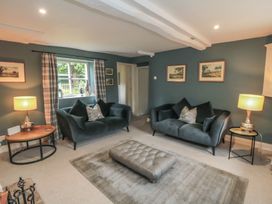 A living room with sofas and a rug at Black Horse Cottage in Swainby