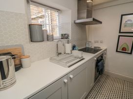 A kitchen with a sink, stove, and appliances at Black Horse Cottage in Swainby