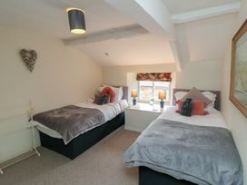 A bedroom with two beds and lamps at Black Horse Cottage in Swainby