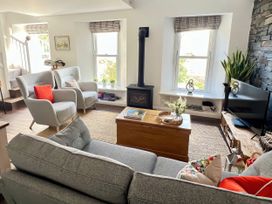A living room with a sofa and chairs near a fireplace at Moorhurst Cottage in Kents Bank near Grange-Over-Sands