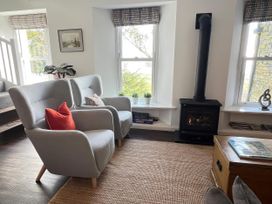 A living room with armchairs and a fireplace at Moorhurst Cottage Kents Bank near Grange-Over-Sands