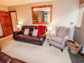 A living room with a sofa and armchair at Greenbank Cottage in Winster near Bowness-On-Windermere
