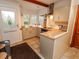 A kitchen with appliances and cabinets at Greenbank Cottage in Winster near Bowness-On-Windermere