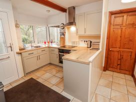 A kitchen with cabinets and appliances at Greenbank Cottage in Winster near Bowness-On-Windermere