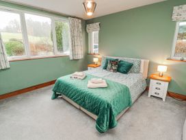 A bedroom with a bed and bedside tables at Greenbank Cottage Winster near Bowness-On-Windermere