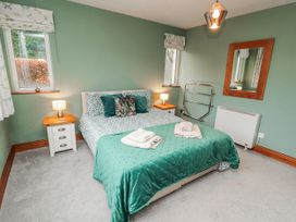 A bedroom with a bed and window at Greenbank Cottage in Winster near Bowness-On-Windermere