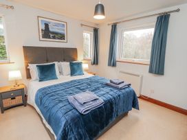 A bedroom with a bed and side tables at Greenbank Cottage in Winster near Bowness-On-Windermere
