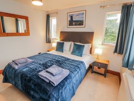A bedroom with a bed and bedside table at Greenbank Cottage in Winster near Bowness-On-Windermere