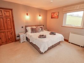 A bedroom with a bed and nightstand at Greenbank Cottage in Winster near Bowness-On-Windermere