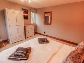 A bedroom with a bed and wardrobe at Greenbank Cottage in Winster near Bowness-On-Windermere