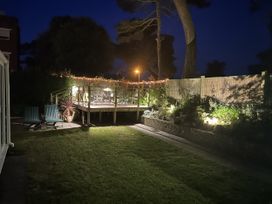 A garden with a deck and furniture at Hoppapill House in Bournemouth
