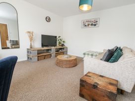 A living room with a television and sofa at Beachcomb in Weymouth