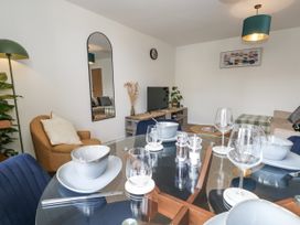 A living room with a dining table and seating area at Beachcomb in Weymouth