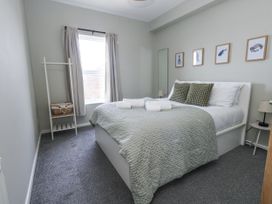 A bedroom with a bed and bedside lamp at Beachcomb in Weymouth