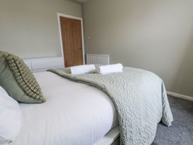 A bedroom with a bed and towels at Beachcomb in Weymouth