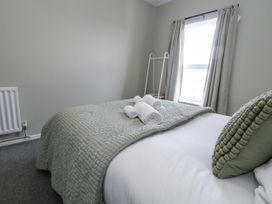 A bedroom with a bed and towels on it at Beachcomb in Weymouth