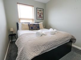 A bedroom with a bed and towels at Beachcomb in Weymouth