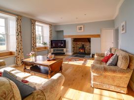 A living room with sofa and television at Porthcothan House in St Merryn